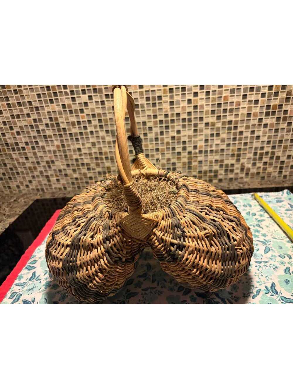 This is a vintage hand-woven double buttocks wicker harvest basket.